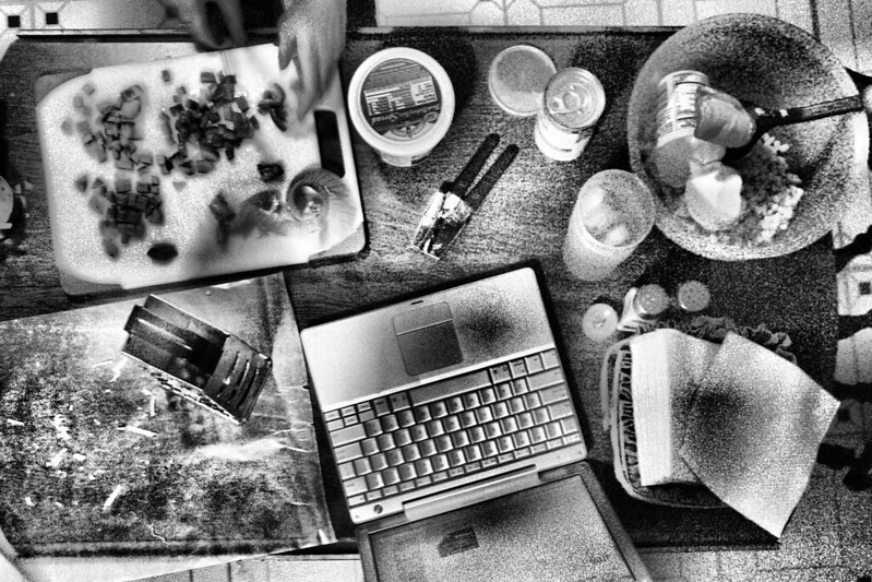 A laptop in the middle of dinner preparations